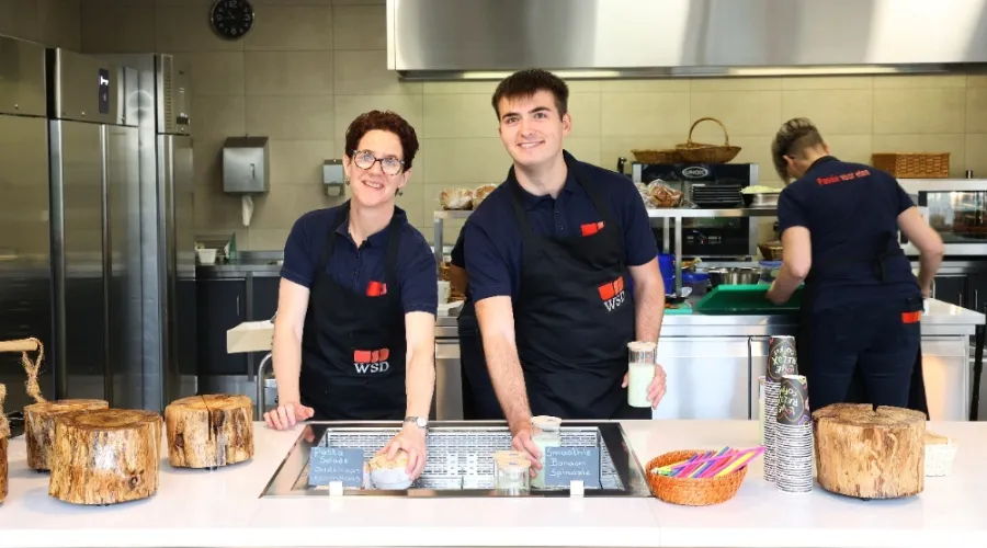 twee collega's van de catering kijken lachend in de camera