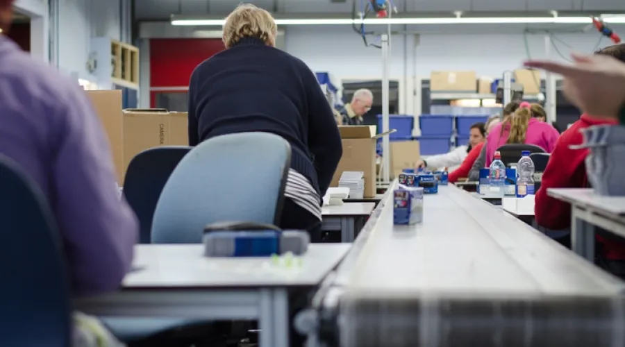 Mensen zitten aan een band en verrichten werk